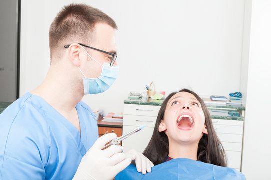 Lady patient at dentist ready to make anesthetic shot