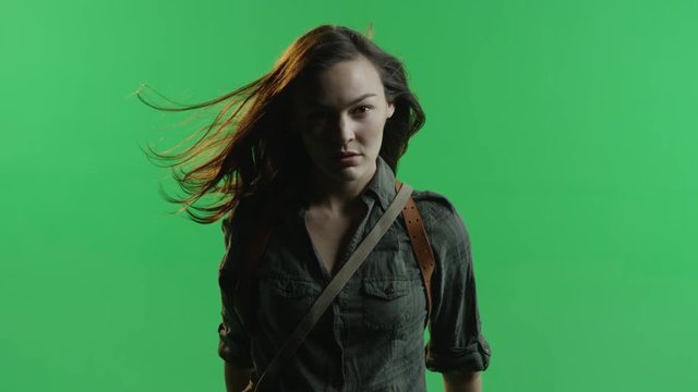 Woman with hair blowing in the wind on green screen