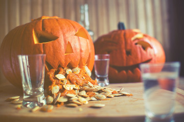  Pumpkin puking with pumpkin seeds on wood table, vodka, vintage effect