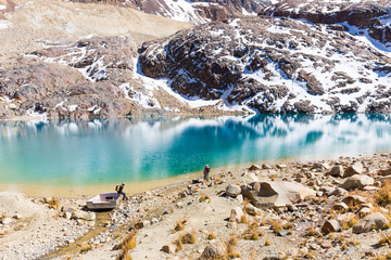 Couple traditional clothing standing mountain lake shore boat, Bolivia landscape travel.