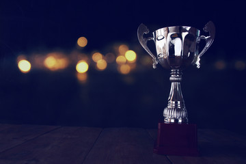 low key image of trophy over wooden table