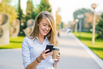 business, communication, technology and people concept - young women smiling and talking on the smarphone