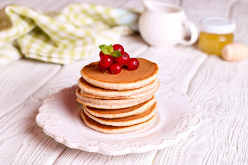 Obraz na płótnie Canvas Stack of fluffy pancakes with berry on top