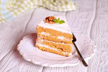 Sweet slice of walnut carrot cake on white plate.