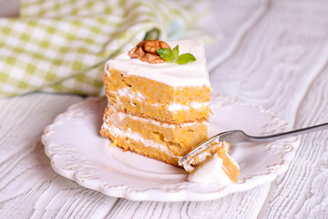 Close up of creamy sweet walnut carrot cake on a fork
