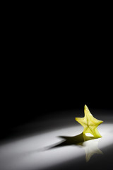 Slice of star fruit on a black background with a beautiful back light.