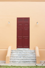 wooden brown door on orange wall