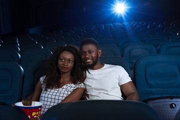 Fototapeta na wymiar Loving couple watching a movie in the empty cinema