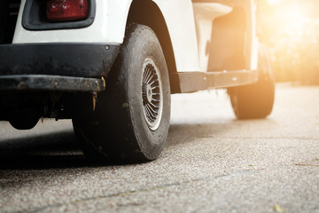 Close up behind the wheel of a golf cart parked on the pavement. © Phawat
