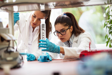 Two young female scientist doing experiments in lab.