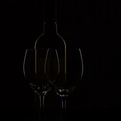 bottle of wine and two glasses on black back