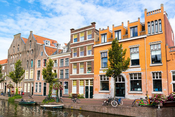 Fototapeta premium Row of historic houses and warehouses on quay of Old Rhine canal in old town of Leiden, South Holland, Netherlands