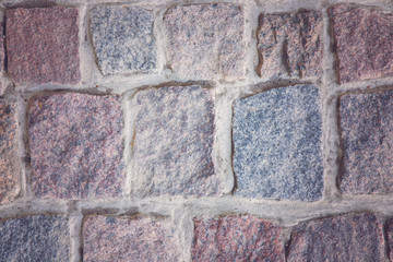 From colorful stones created squares pavement. The light shines in the middle. Background.
