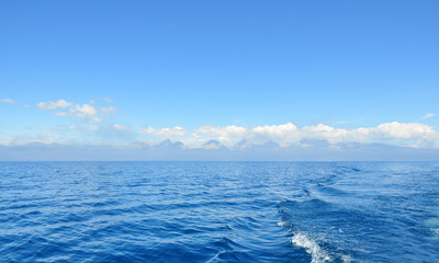Naklejka na ściany i meble sea lanscape. blue sky, clouds over the surface of sea. mountain on horizon