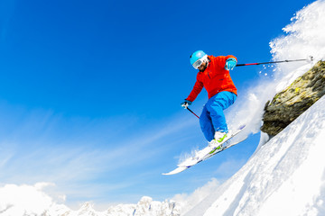 Naklejka na ściany i meble Man skiing in fresh powder snow in Italians Alps, captured jump