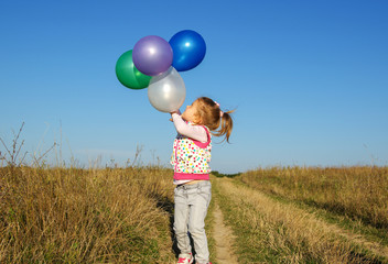  girl outdoors with balloons