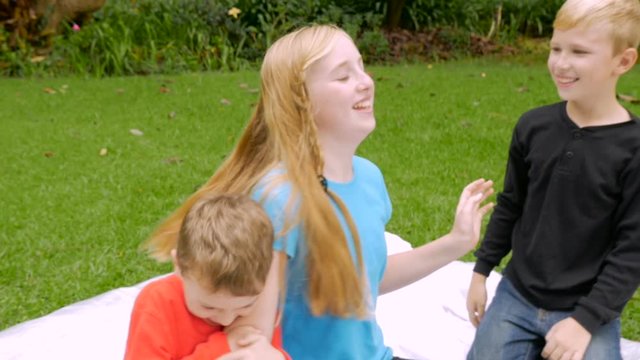 A group of young kids playing and tickling each other outside - slowmo steadicam