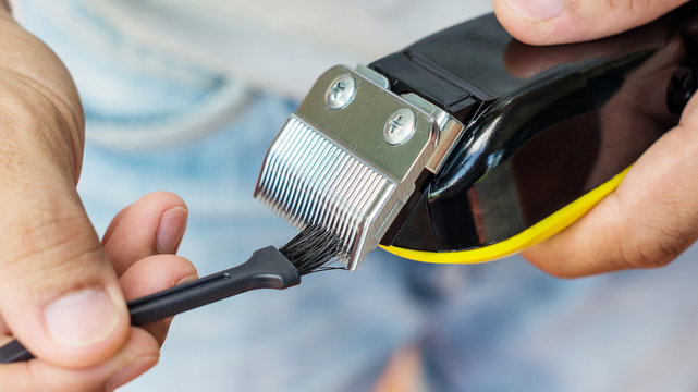 Man Cleaning Black Hair Clippers.