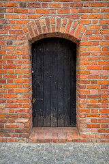 Red brick wall and the wodden closed door