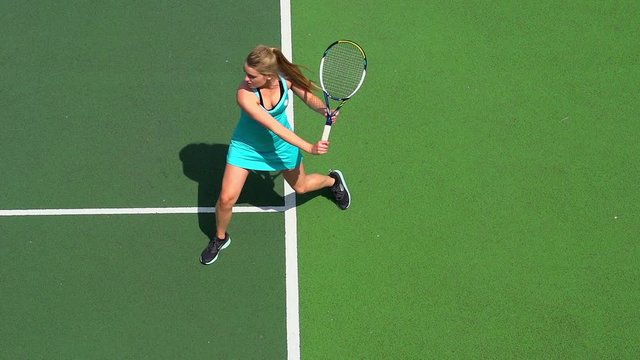 Young female tennis player backhand return.