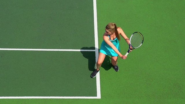 Young female tennis player backhand return.