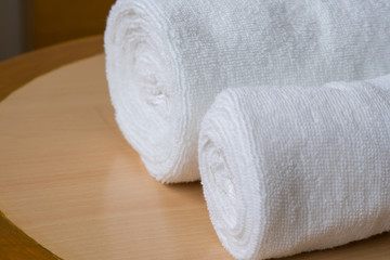 soft bath towel rolled up on wooden table