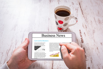 Tablet with personal loan in hands and black coffee on wooden table.  
