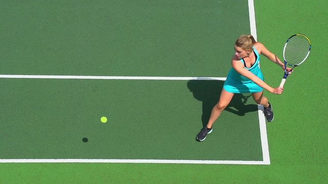 Young female tennis player runs to backhand return.