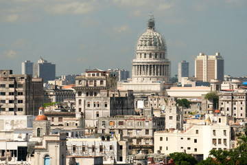 Fototapeta na wymiar Reconstructed Capitol, ancient ragged houses and cityscape of Havana at summer sunny day