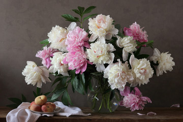 Still-life with a bouquet of peonies and peaches.