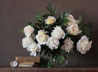 Still-life with a bouquet of yellow peonies and books.
