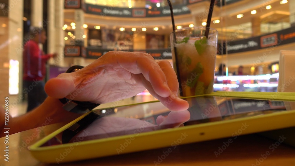 Poster hand gestures over tablet computer in cafe. bokeh background