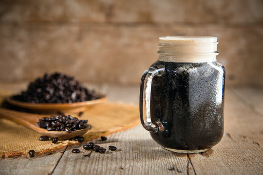 Dark rich beautiful froth foam nitro black coffee in a glass jar java