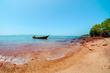 small fishing boat in the sea at red rock island, satun province