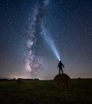 Man with head torch looking at milky way