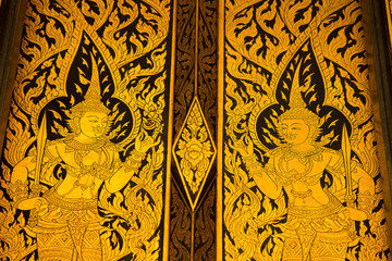 Fototapeta na wymiar god in Thai style hand painting art golden color on window of the temple