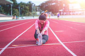 Beautiful woman fitness runner stretching legs before run,worm u
