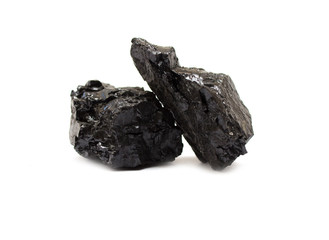 Two pieces of anthracite coal on white. Coal is one of the most common fossil fuels and is a major...
