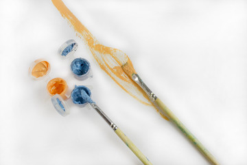 Used brushes on an artist's palette of colorful acrylic paint for drawing and painting. Painting with acrylic paints, brushes, paint, canvas