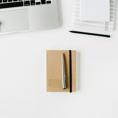 Flat lay home office workspace with laptop, craft diary on white background.