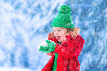 Little girl playing in snowy park