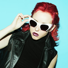 Model Glam Rock style. Red hair trend and stylish glasses