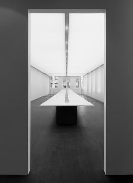 View through doorway of dining table in empty room, black and white image