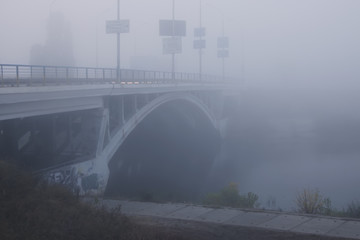 Dense fog in the city. The bridge is almost not visible. Early morning in Kyiv 