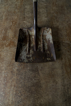 Rusty shovel head on metal floor