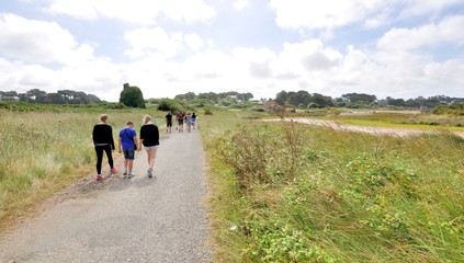 Groupe de jeunes gens sur le sentier côtier GR34 à Plougrescant en Bretagne