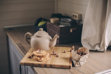 Tea pot and cookies in rustic grey kitchen interior. Slow living in country house concept. Cozy morning at home