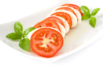Caprese salad with mozzarella cheese, tomatoes and basil isolated on white background

