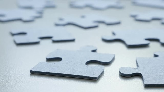 Slow tilt over problem solving toys arranged chaotically DOF 4K 2160p 30fps UHD tilting footage - Jigsaw puzzle blue pieces on the table shallow 3840X2160 UltraHD video 