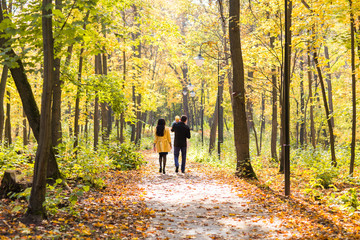 Obraz premium happy young family with their daughter spending time outdoor in the autumn park